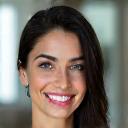 Ritratto sorridente di Alessia G., indossando abiti casual, con uno sfondo sfocato e moderno.