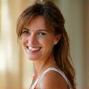 Ritratto professionale di Giulia C., sorridente, con uno sfondo neutro e luminoso.